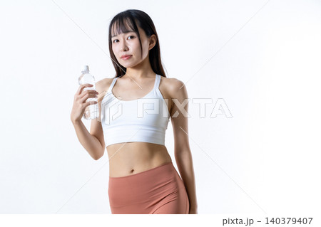 水のペットボトルを持って体を鍛える女性 ジムで運動イメージ 筋トレ女子 トリミングアップ 水のペットボトルを持って体を鍛える女性 ジムで運動イメージ 筋トレ女子 トリミングアップ 140379407