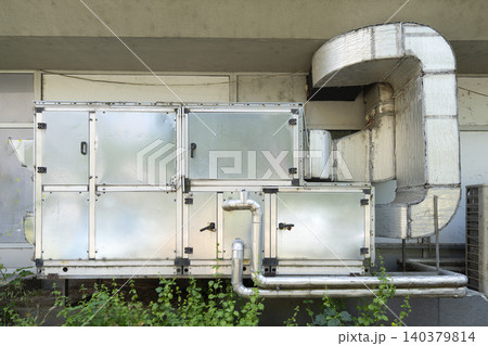 An industrial air conditioning unit is shown mounted on a building exterior. An industrial air conditioning unit is shown mounted on a building exterior. 140379814