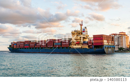 Miami, Florida, USA - November 25, 2024: Container ship. Cargo Annie B Monrovia ship services with container leaving port, aerial view. Freight container on cargo vessel. Cargo ship vessel Miami, Florida, USA - November 25, 2024: Container ship. Cargo Annie B Monrovia ship services with container leaving port, aerial view. Freight container on cargo vessel. Cargo ship vessel 140380113