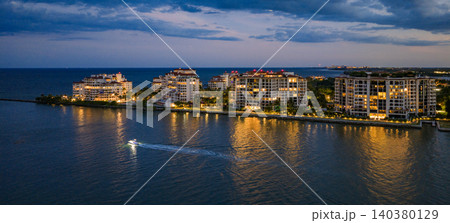 Aerial night view of Miami coastline. Twilight skyline above the Miami oceanfront. Miami Beach waterfront glowing after sunset. Famous Miami Beach from above. 140380129