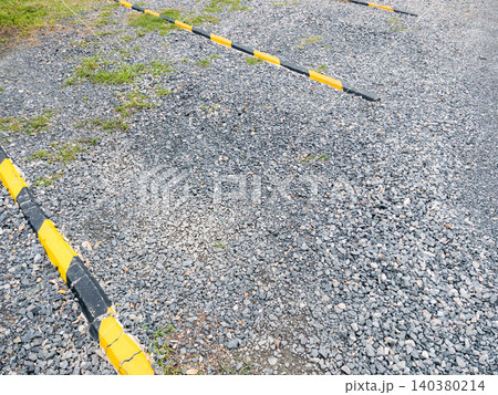 Gravel Parking Lot with Wheel Stops and Empty Outdoor Parking Space Gravel Parking Lot with Wheel Stops and Empty Outdoor Parking Space 140380214