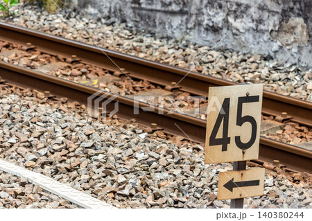 線路と速度制限標識 45キロ 鉄道のレールとバラスト 矢印 線路と速度制限標識 45キロ 鉄道のレールとバラスト 矢印 140380244