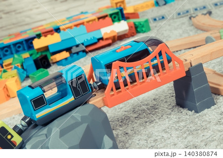Train on plastic bridge with wooden toy tracks Train on plastic bridge with wooden toy tracks 140380874