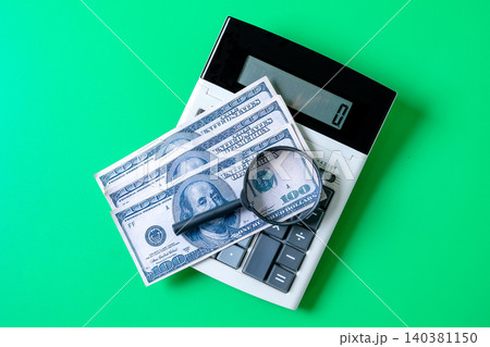 Bank note on calculator with magnifying glass,Business concept. Bank note on calculator with magnifying glass,Business concept. 140381150
