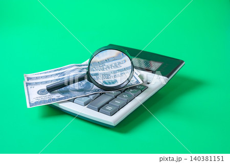 Bank note on calculator with magnifying glass,Business concept. 140381151