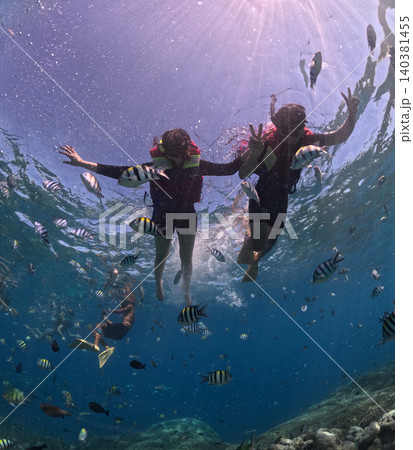 Tropical snorkeling adventure with colorful reef fish in clear blue waters Tropical snorkeling adventure with colorful reef fish in clear blue waters 140381455