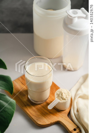 Protein shake glass with sports nutrition supplement and scoop Protein shake glass with sports nutrition supplement and scoop 140382676