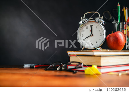 Back to School Supplies on Wooden Desk with Alarm Clock, Apple and Colored Pencils Back to School Supplies on Wooden Desk with Alarm Clock, Apple and Colored Pencils 140382686