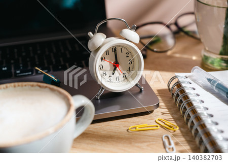 Time management concept with alarm clock, laptop and coffee on home office desk, top view workspace Time management concept with alarm clock, laptop and coffee on home office desk, top view workspace 140382703