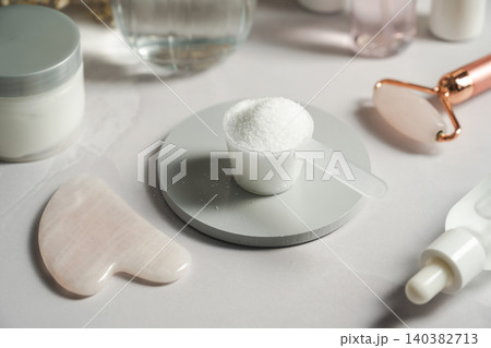 Collagen powder scoop beside glass of water and skincare products Collagen powder scoop beside glass of water and skincare products 140382713