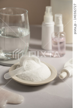 Collagen powder scoop beside glass of water and skincare products Collagen powder scoop beside glass of water and skincare products 140382727