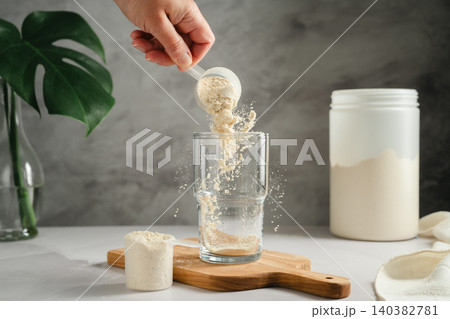 Protein powder being poured into glass, sports nutrition concept Protein powder being poured into glass, sports nutrition concept 140382781