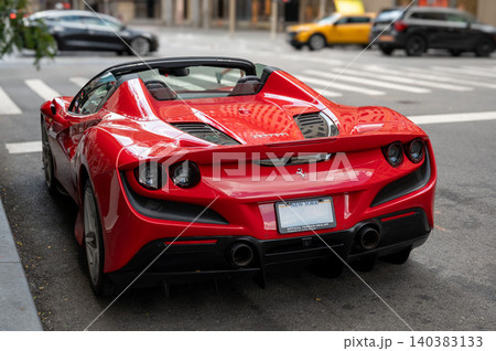 New york, usa august 22,2024. Red ferrari convertible parked on a manhattan street, rear view highlighting sleek modern design, luxury performance and urban style New york, usa august 22,2024. Red ferrari convertible parked on a manhattan street, rear view highlighting sleek modern design, luxury performance and urban style 140383133