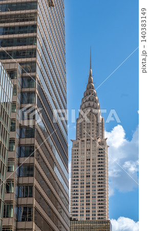 New york, usa august 22,2024. Chrysler building showcasing art deco architecture, framed by a modern glass skyscraper in manhattan, new york city skyline 140383149