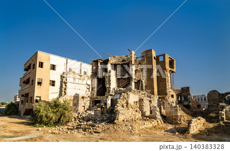 View of traditional coral stone buildings and ruins within the Yanbu Historic Area under a clear sky in Saudi Arabia. View of traditional coral stone buildings and ruins within the Yanbu Historic Area under a clear sky in Saudi Arabia. 140383328
