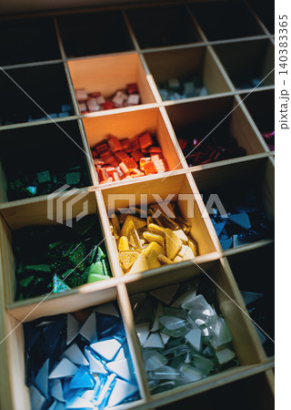 Colorful glass mosaic tiles in organized grid compartments for art and craft design, Assorted vibrant mosaic pieces collection for creative projects and decorative patterns Colorful glass mosaic tiles in organized grid compartments for art and craft design, Assorted vibrant mosaic pieces collection for creative projects and decorative patterns 140383365