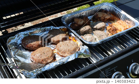 Grilled patties sizzle on a barbecue grill Grilled patties sizzle on a barbecue grill 140383422