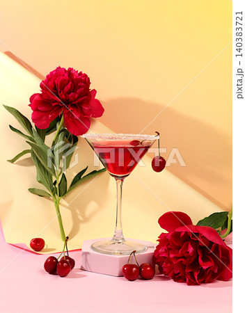 Modern still life with a summer alcoholic cocktail and peony flowers against a sunny background. Cherry martini on the rocks for a party. Minimalistic concept for a bar or cafe. Advertising banner 140383721