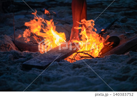 Feet Walking Over Embers on Beach at Night During Summer Solstice Celebration 140383752