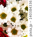 White little flowers with yellow centers closely arranged together, decorative background for design. Red flowers providing contrast. Fresh and vibrant bouquet, natural beauty 140384336