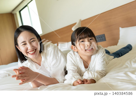 ベッドに寝転ぶ親子 ベッドに寝転ぶ親子 140384586