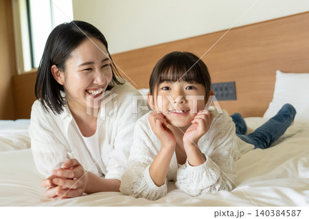 ベッドに寝転ぶ親子 140384587
