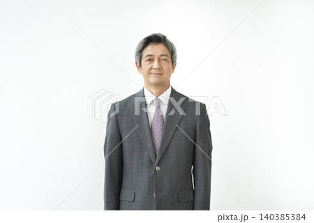 カメラ目線で微笑むスーツ姿の60代の男性 140385384