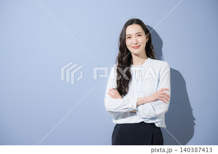 自信や信頼性の高いカッコイイハンサムな女性のビジネスイメージ　カメラ目線で笑顔で腕組み 140387413
