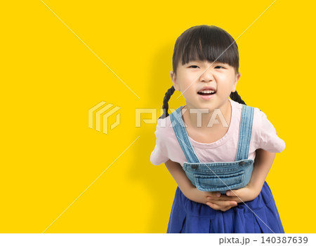 Child having stomach ache holding belly with uncomfortable facial expression Child having stomach ache holding belly with uncomfortable facial expression 140387639
