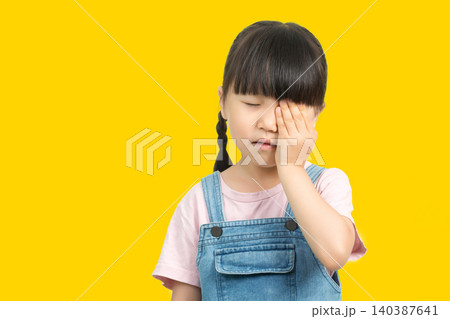 Little girl rubbing eye or feeling eye pain with one hand Little girl rubbing eye or feeling eye pain with one hand 140387641