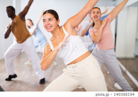 Men and women having dance training in modern studio, performing contemporary dance elements 140388194