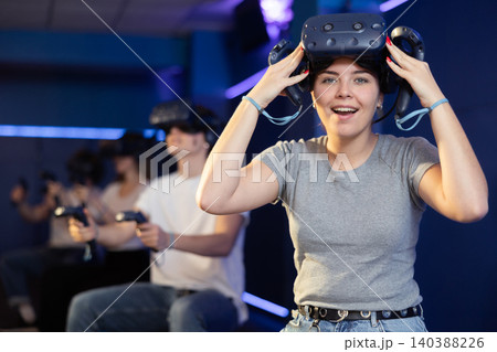girl is exhilarated by turn of events in VR game and moved virtual reality glasses to forehead girl is exhilarated by turn of events in VR game and moved virtual reality glasses to forehead 140388226