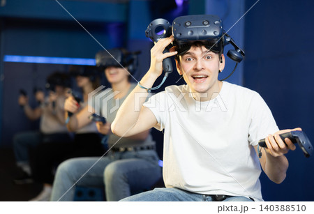 Excited young guy in VR glasses playing virtual reality game Excited young guy in VR glasses playing virtual reality game 140388510