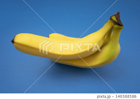 Bunch of Ripe Yellow Bananas on Blue Background	 140388586