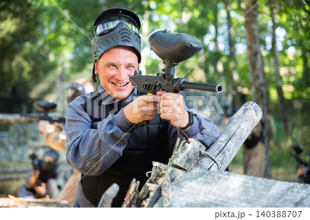 Man and his paintball sport team in uniform at paintball shooting range Man and his paintball sport team in uniform at paintball shooting range 140388707
