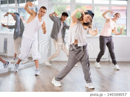 Young girl practicing basic hip hop moves in training hall Young girl practicing basic hip hop moves in training hall 140389057