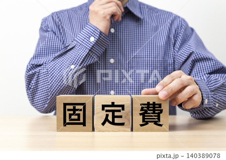 「固定費」と書かれたブロックと男性 「固定費」と書かれたブロックと男性 140389078