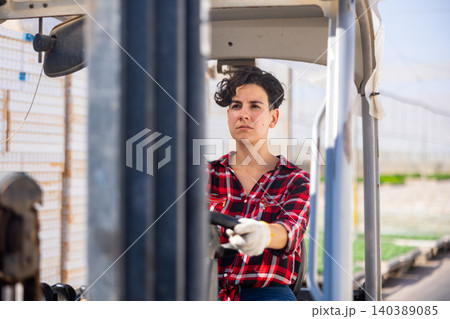 Chilean woman forklift worker operator driving vehicle at greenhouse Chilean woman forklift worker operator driving vehicle at greenhouse 140389085