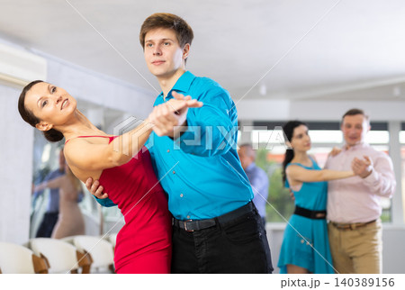 Guy and woman dancing slow ballroom dance in choreography studio 140389156