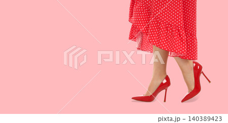 Woman wearing red high heels with a polka dot dress Woman wearing red high heels with a polka dot dress 140389423