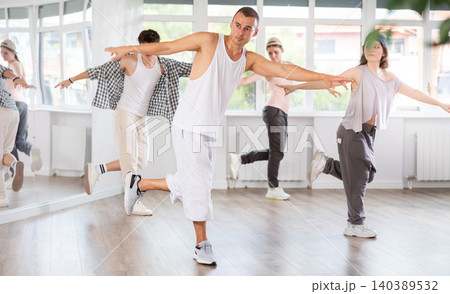 Dance group in casual clothes training to dance hip-hop and breakdance together in dance center 140389532