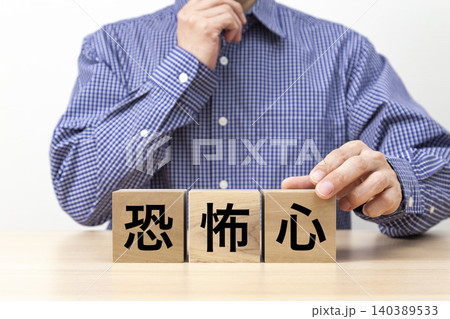 「恐怖心」と書かれたブロックと男性 140389533