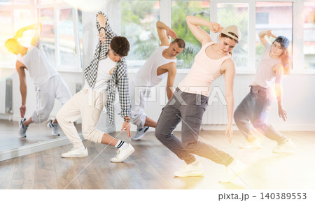 Active group sporty people practicing hip-hop dance in training hall during dancing classes Active group sporty people practicing hip-hop dance in training hall during dancing classes 140389553