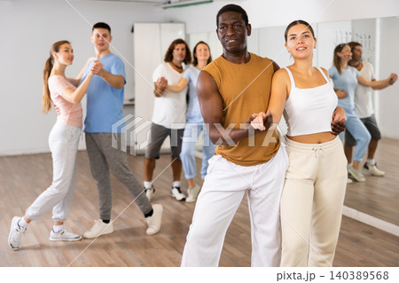 Men and women practicing salsa moves in dancing room Men and women practicing salsa moves in dancing room 140389568