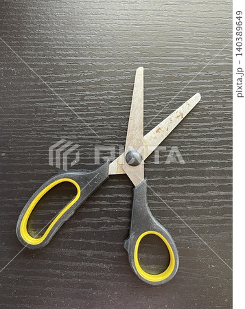 Wide Open Rusted Utility Scissors On Dark Wood Table 140389649