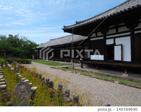 数多の石仏が見守る国宝の伽藍。世界遺産・元興寺の『禅室』へと続く白砂の参道と初夏の空 数多の石仏が見守る国宝の伽藍。世界遺産・元興寺の『禅室』へと続く白砂の参道と初夏の空 140389690