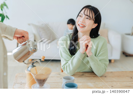 コーヒーを淹れる男性の手と待っている女性 コーヒーを淹れる男性の手と待っている女性 140390047