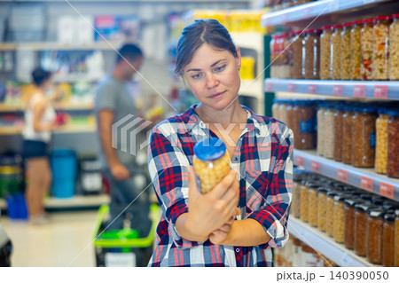 Woman selecting pickled products in grocery store 140390050