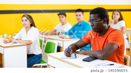 Multiethnic group of people studying together at tables. Focus on African american man 140390055