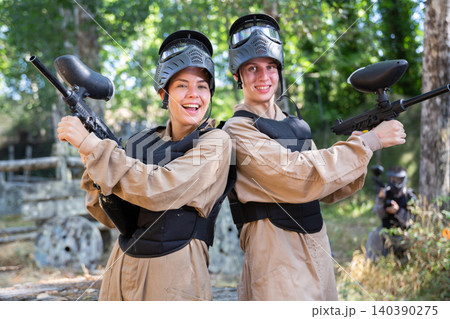 Portrait of positive young woman and man paintball players Portrait of positive young woman and man paintball players 140390275